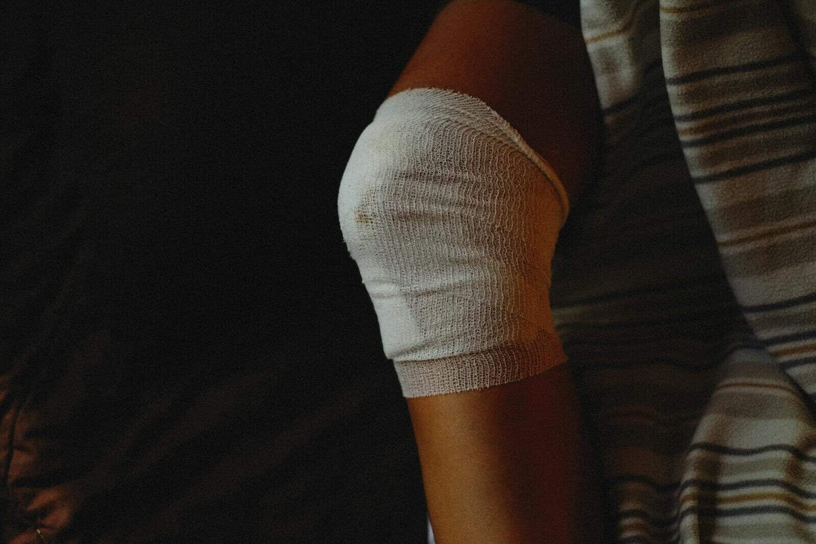 A detailed view of a bandaged knee indicating injury care and healing process.