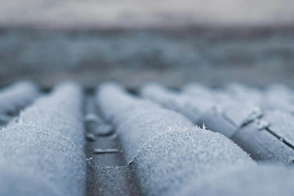 Current image: Close-up of frosty roof shingles showcasing winter's icy grip and cold atmosphere.