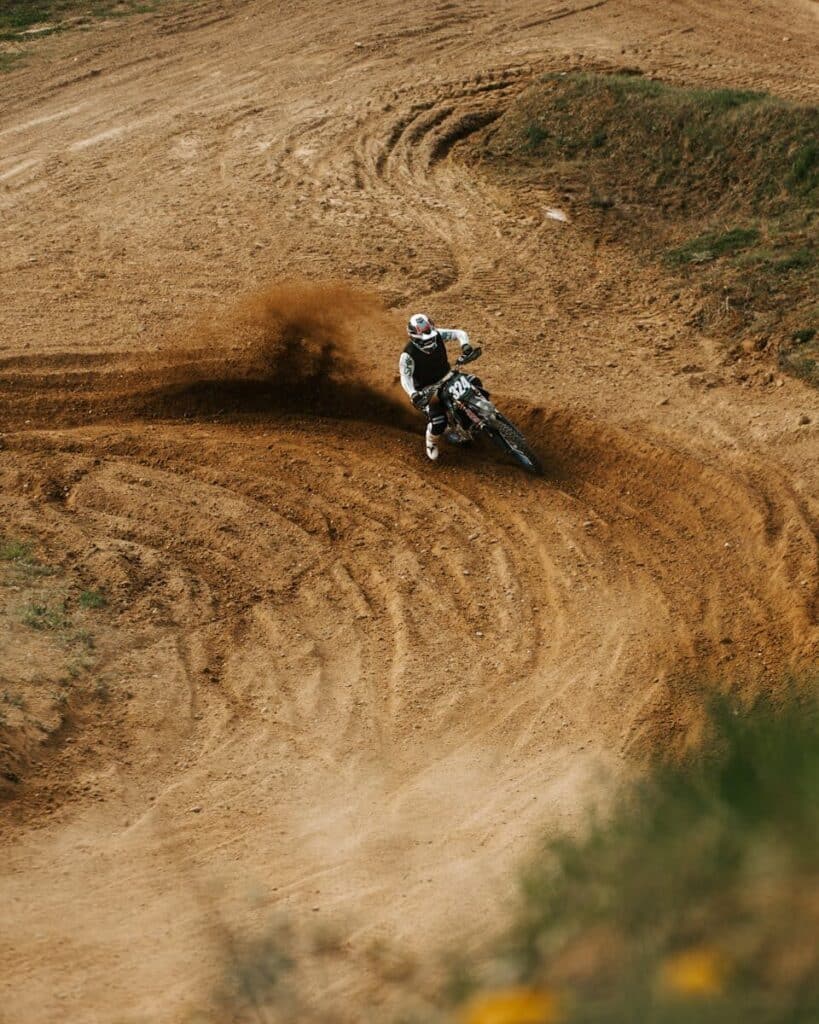 Current image: Dynamic capture of a motocross rider performing on a dirt track in Germany, showcasing skill and speed.