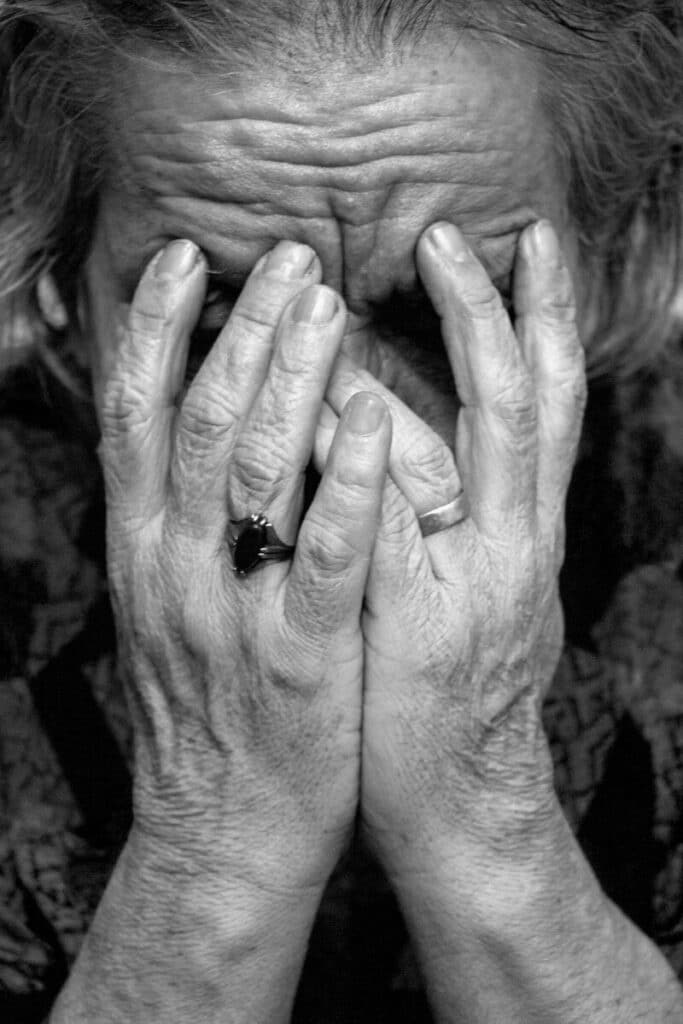 Current image: a woman covering her face with her hands