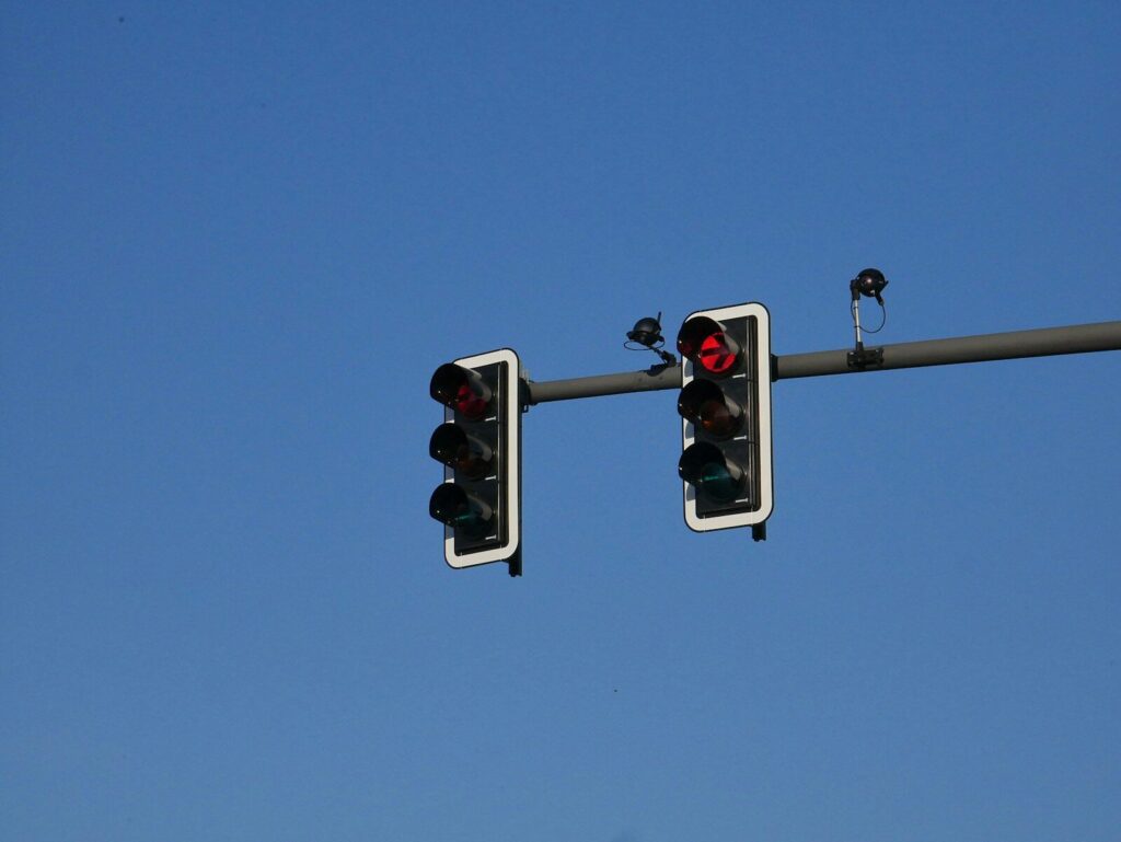 Current image: a couple of traffic lights hanging from a metal pole