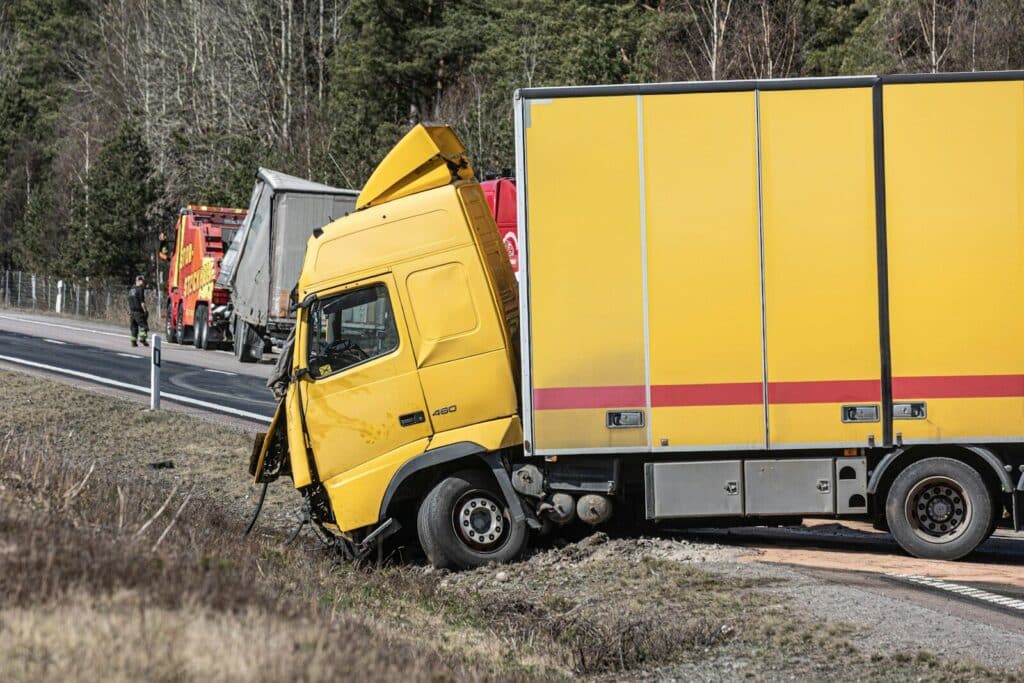 Current image: A yellow semi-truck is in a roadside accident.