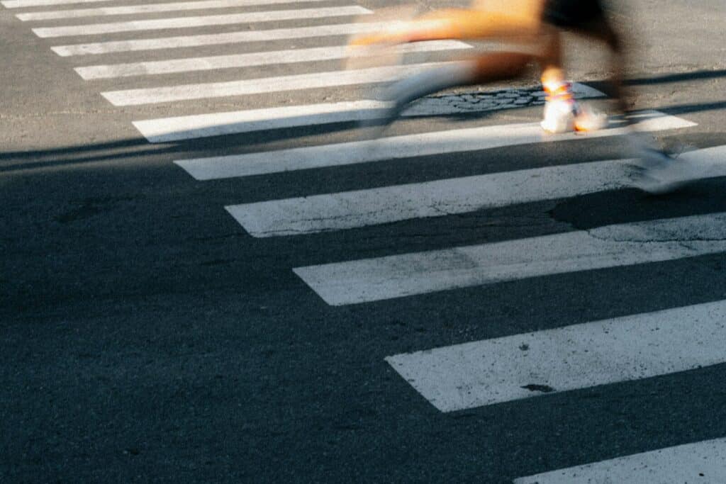 Current image: Person blurred crossing a street on a crosswalk